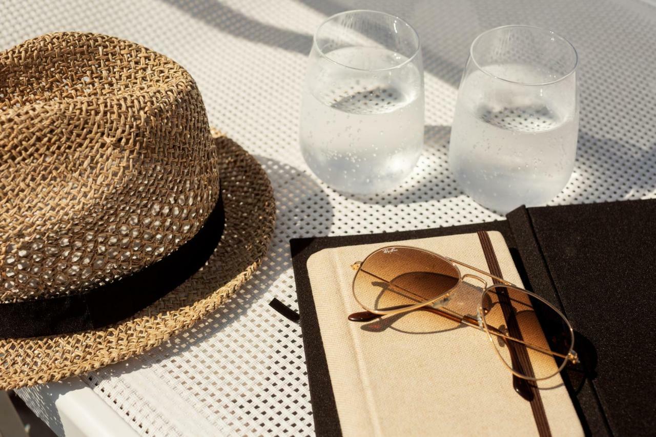 Toscana Charme Resort Tirrenia Exterior foto A hat, sunglasses, and a book
